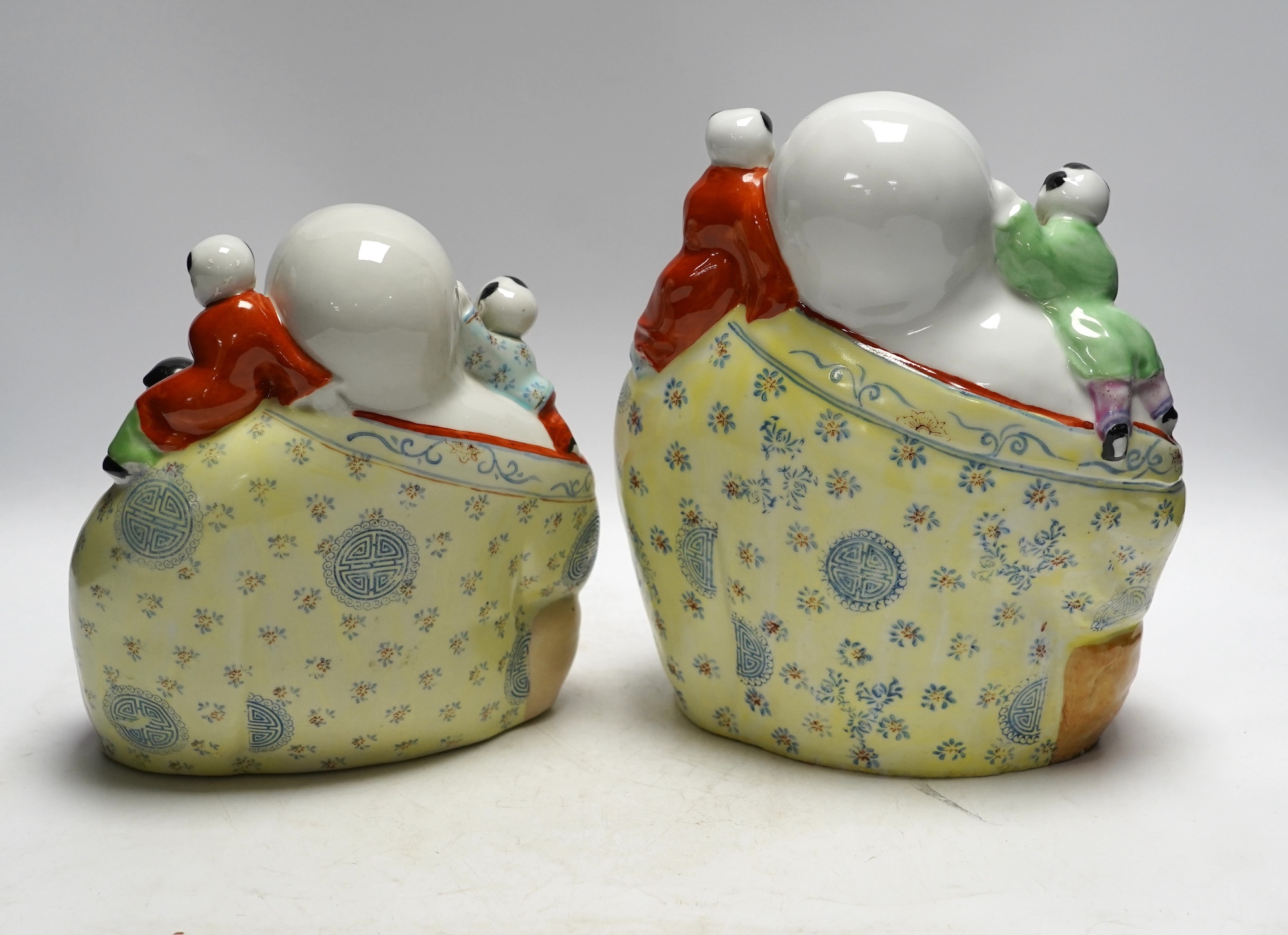 Two figural Chinese pillows, two famille rose Budai groups and three yixing teapots, tallest 25cm